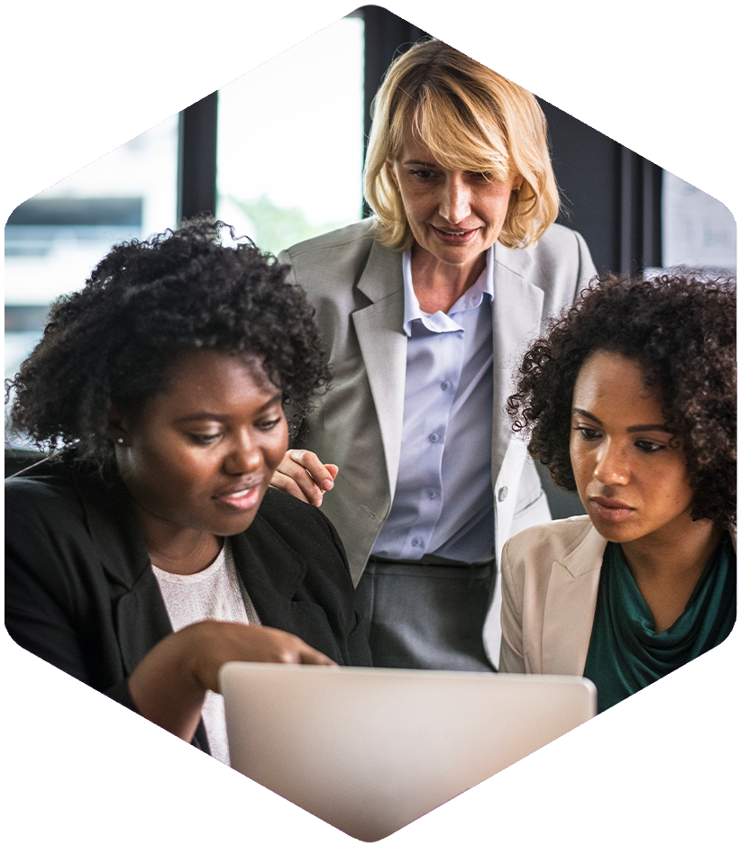 Three professional women review modeling and simulation results on a laptop screen.