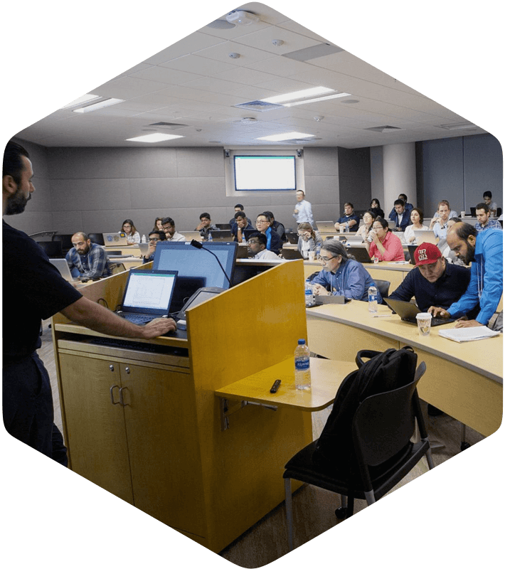 A lecturer presents MedChem Designer tools to attentive students using a projector in a bright room.